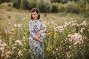 kobieta w ciąży na tle traw